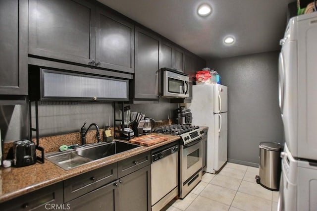 kitchen featuring washer / clothes dryer, appliances with stainless steel finishes, sink, and light tile patterned floors