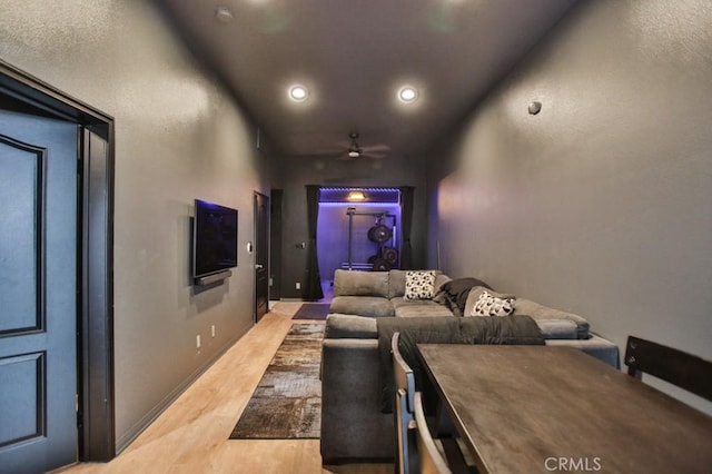 home theater room featuring ceiling fan and light wood-type flooring