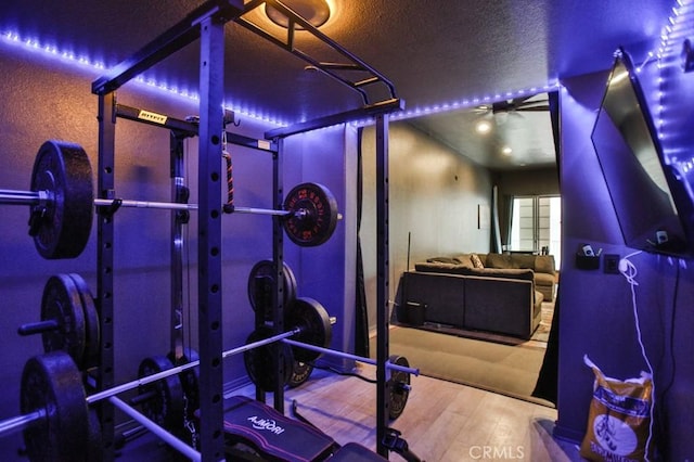 exercise room with wood-type flooring and a textured ceiling