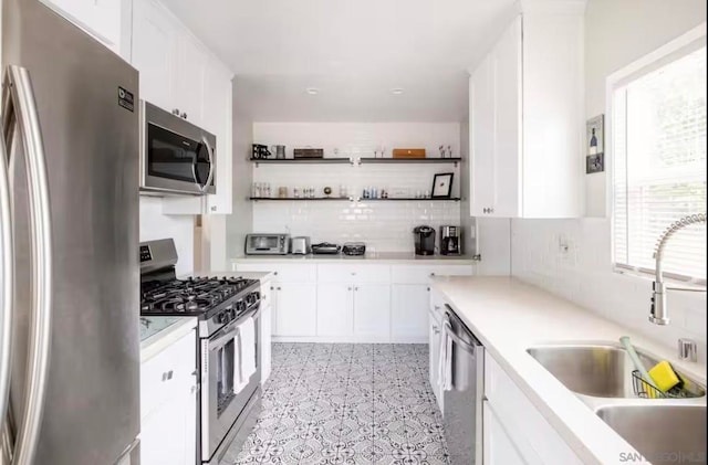 kitchen featuring stainless steel appliances, white cabinetry, sink, and a healthy amount of sunlight