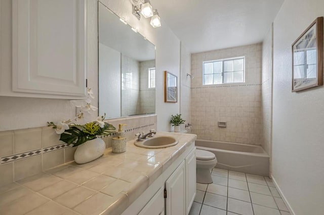 full bathroom featuring vanity, toilet, tiled shower / bath combo, and tile patterned flooring