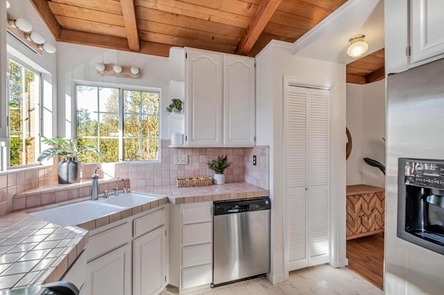 kitchen featuring wood ceiling, stainless steel appliances, tile countertops, and white cabinets