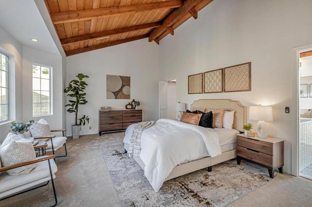 bedroom with beam ceiling, high vaulted ceiling, ensuite bathroom, light carpet, and wooden ceiling