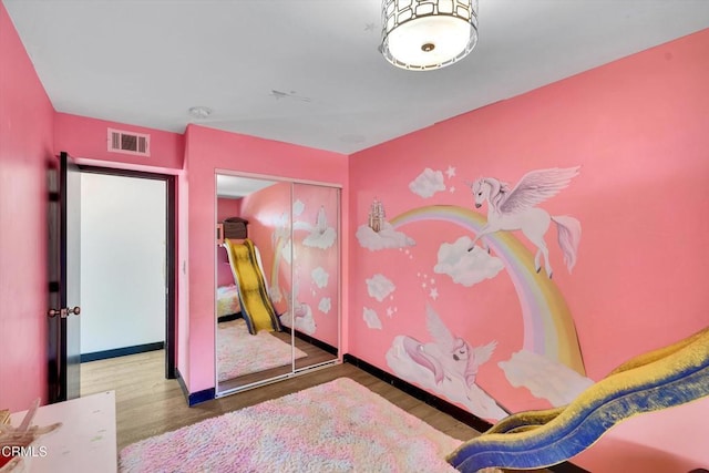 bedroom with wood-type flooring and a closet