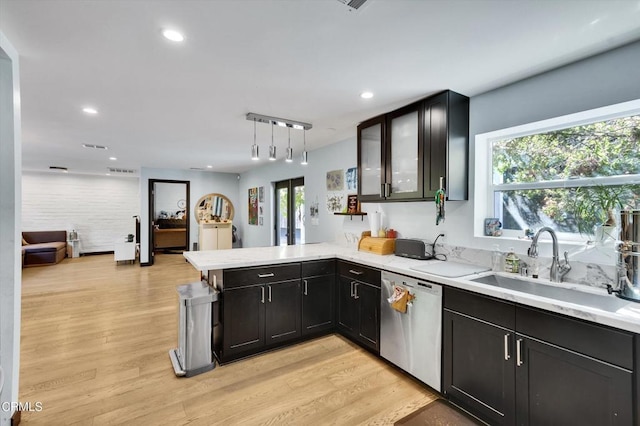 kitchen featuring sink, hanging light fixtures, stainless steel dishwasher, kitchen peninsula, and light wood-type flooring