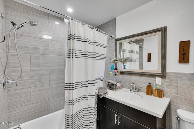 full bathroom with vanity, toilet, tile walls, and shower / tub combo with curtain