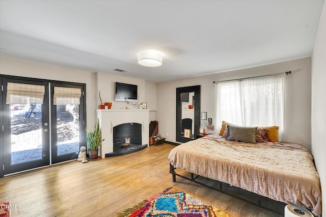 bedroom with french doors, wood-type flooring, and access to exterior