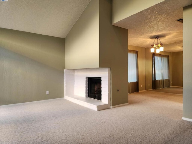 unfurnished living room with a towering ceiling, carpet flooring, a brick fireplace, and a notable chandelier