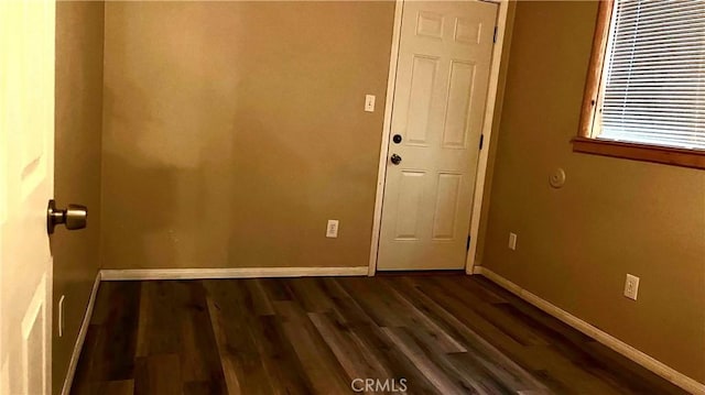 empty room with dark hardwood / wood-style flooring