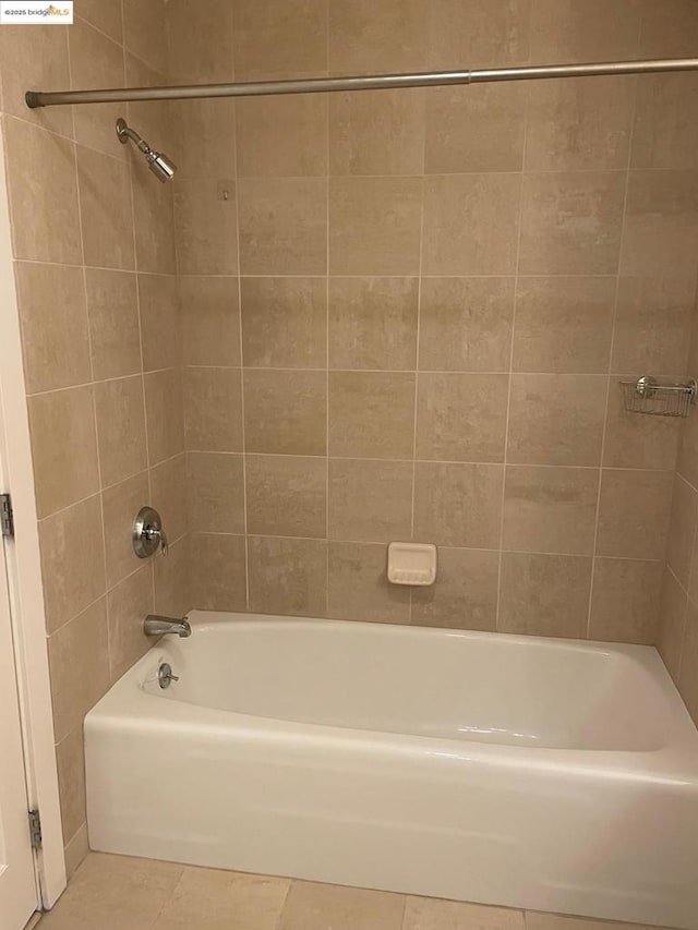 bathroom featuring tiled shower / bath combo and tile patterned flooring