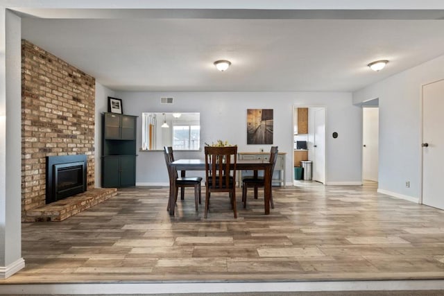 dining room featuring a fireplace and wood-type flooring