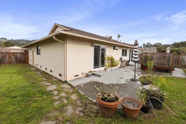 back of property with a patio area and a lawn