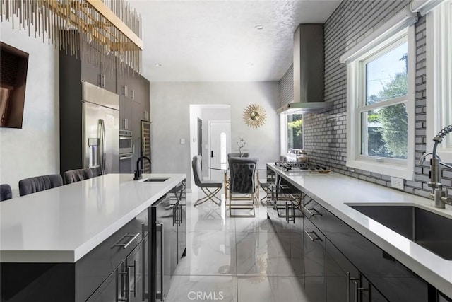 kitchen featuring sink, stainless steel appliances, beverage cooler, and wall chimney exhaust hood