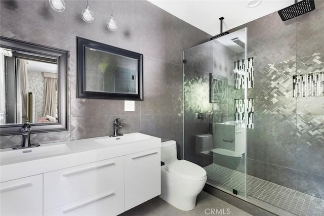 bathroom featuring walk in shower, toilet, tile walls, vanity, and tile patterned flooring