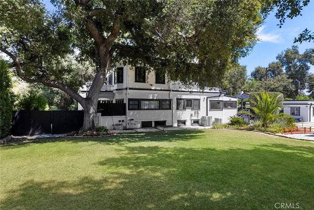 rear view of property featuring a yard and central AC