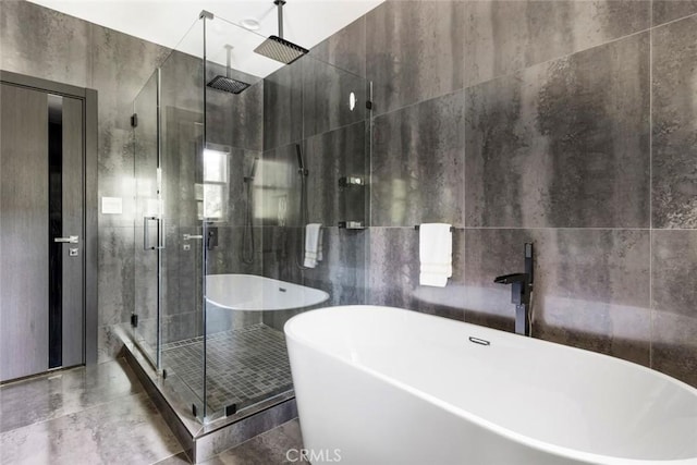 bathroom with separate shower and tub and tile walls