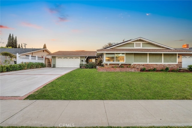 single story home with a garage and a lawn