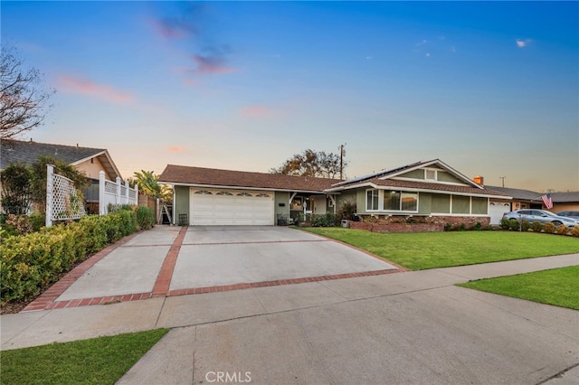 ranch-style home with a garage and a lawn