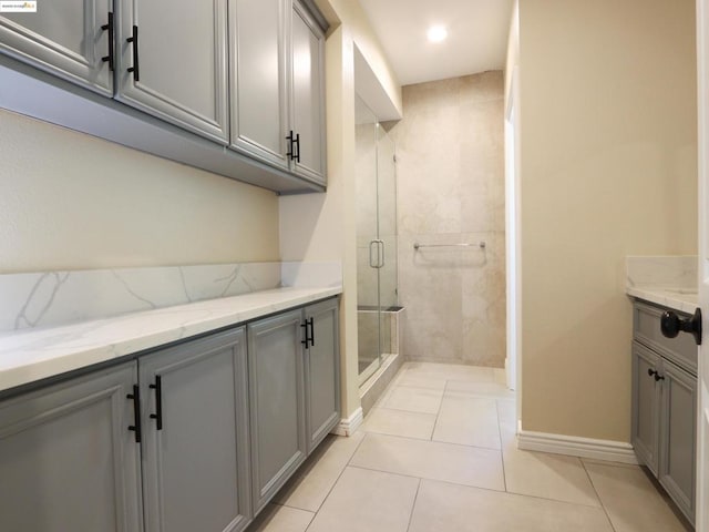 bathroom with vanity, a shower with shower door, and tile patterned flooring