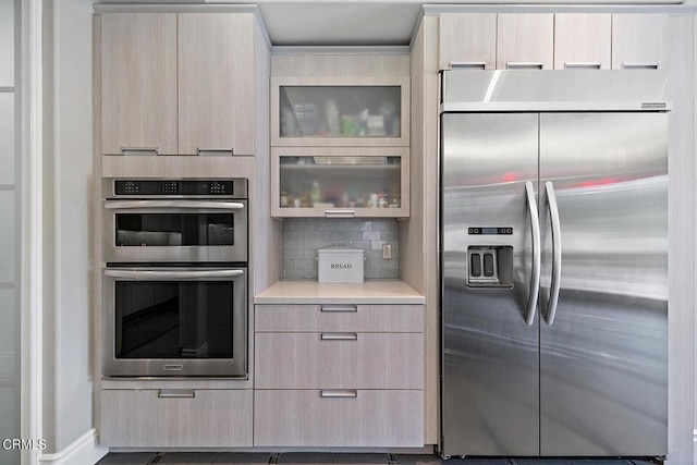 kitchen featuring tasteful backsplash, appliances with stainless steel finishes, and light brown cabinetry