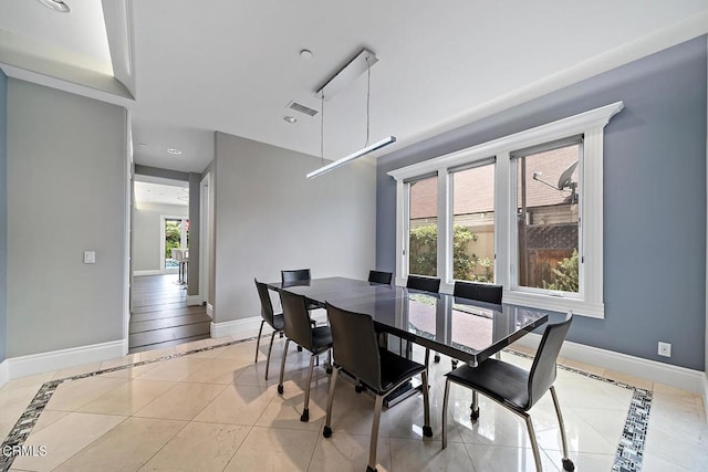 tiled dining area featuring a healthy amount of sunlight