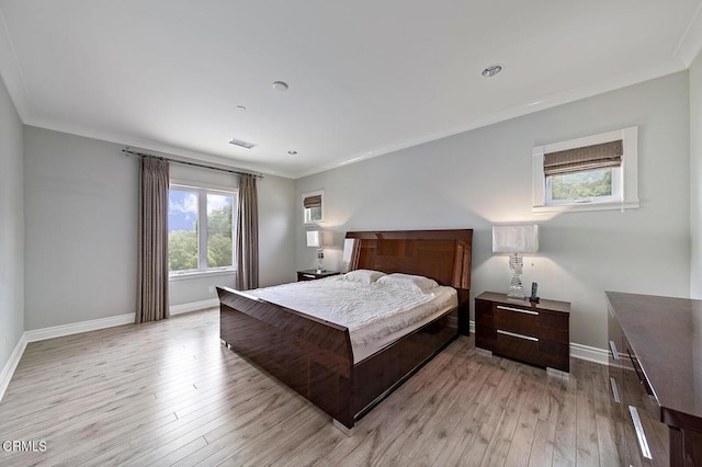 bedroom with crown molding and light hardwood / wood-style flooring