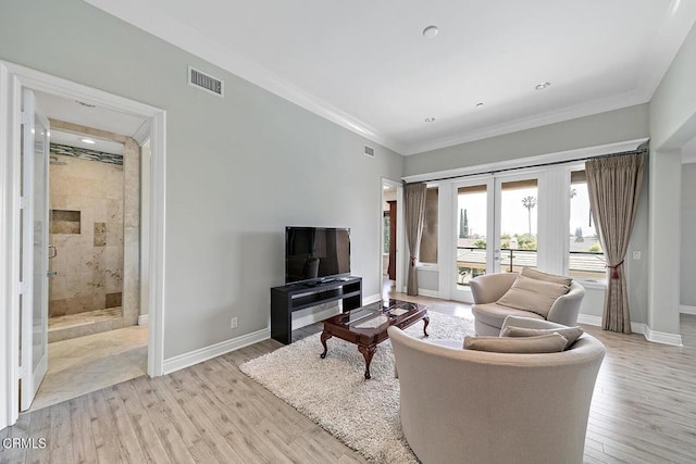 living room with ornamental molding, light hardwood / wood-style floors, and french doors