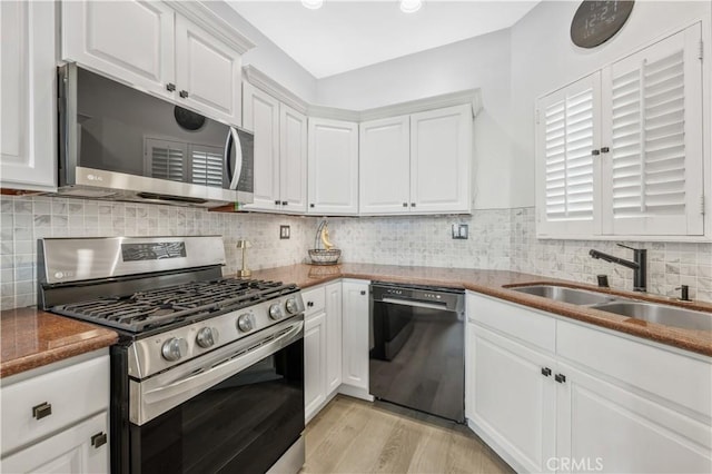 kitchen with white cabinetry, sink, stainless steel appliances, and light wood-type flooring