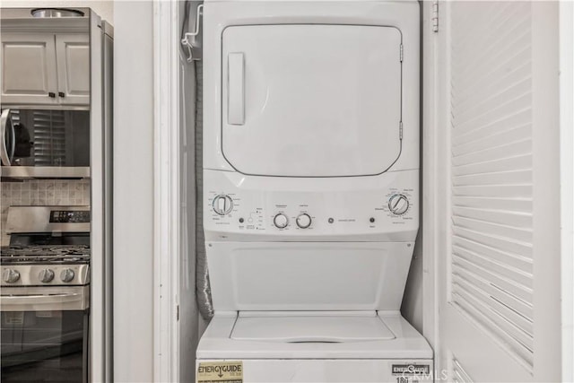 washroom featuring stacked washer / drying machine