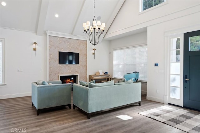 living room featuring high vaulted ceiling, a fireplace, a chandelier, hardwood / wood-style flooring, and beam ceiling