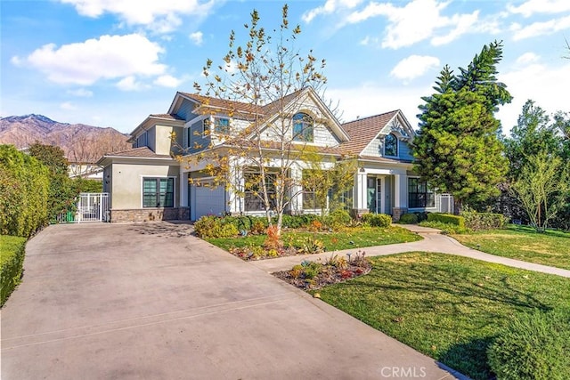 view of front of house with a garage, a mountain view, and a front yard