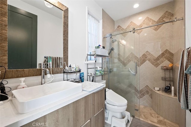 bathroom with toilet, sink, and a shower with shower door