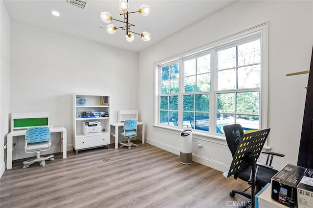 office area featuring plenty of natural light, a notable chandelier, and light wood-type flooring