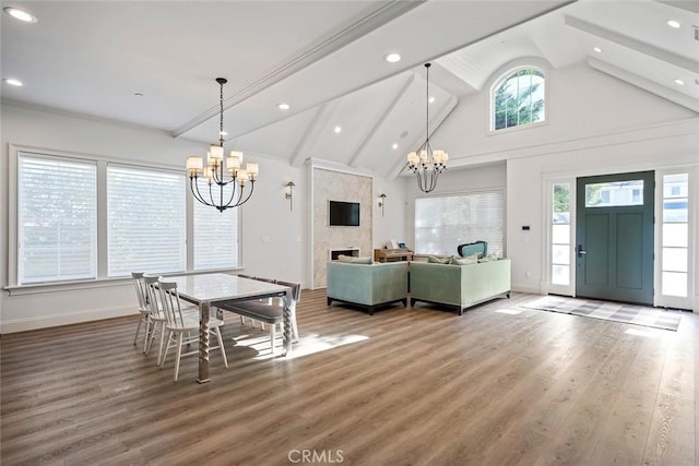 dining area featuring high vaulted ceiling, hardwood / wood-style floors, a notable chandelier, and beam ceiling