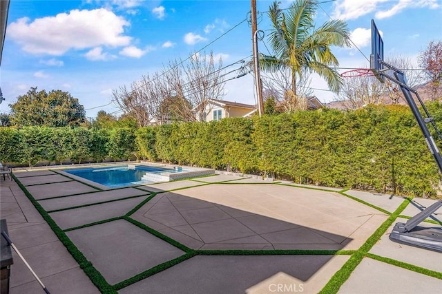 view of pool featuring an in ground hot tub, basketball hoop, and a patio area