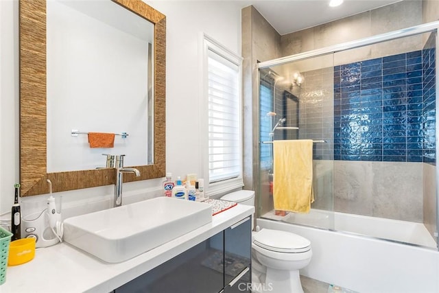 full bathroom featuring vanity, enclosed tub / shower combo, and toilet