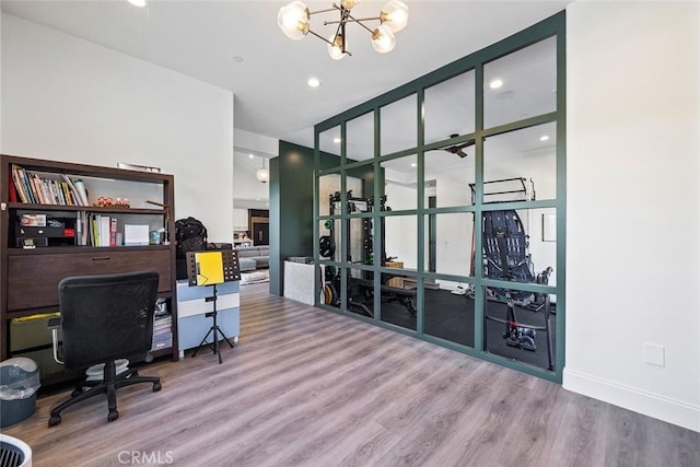 home office with hardwood / wood-style flooring and a notable chandelier