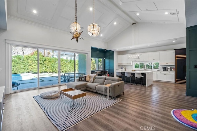 living room featuring hardwood / wood-style flooring, a healthy amount of sunlight, beam ceiling, and high vaulted ceiling