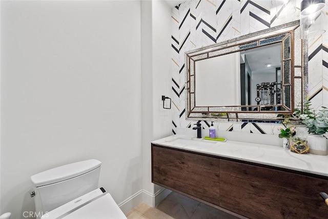 bathroom featuring tile patterned flooring, vanity, and toilet