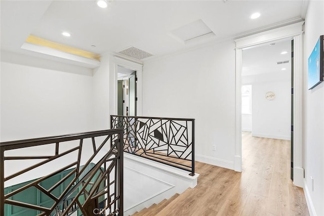 corridor with hardwood / wood-style floors and ornamental molding