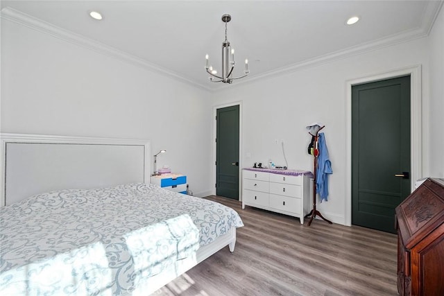 bedroom featuring hardwood / wood-style flooring, ornamental molding, and a chandelier