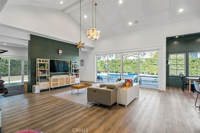 living room with beam ceiling, wood-type flooring, and high vaulted ceiling