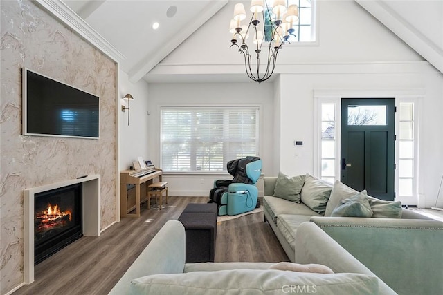 living room with crown molding, hardwood / wood-style flooring, a premium fireplace, vaulted ceiling with beams, and a chandelier