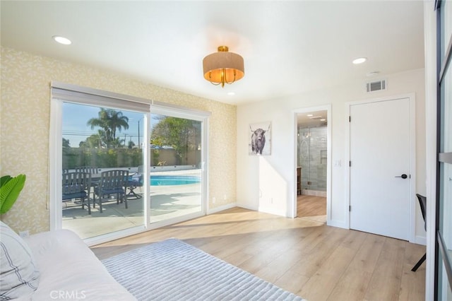 bedroom with ensuite bathroom, access to outside, and light hardwood / wood-style flooring