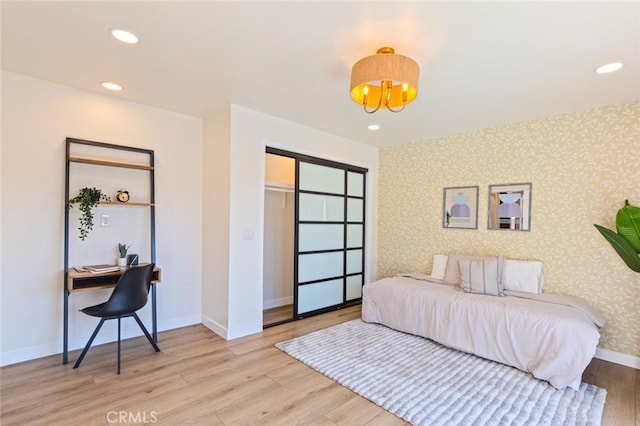 bedroom with light hardwood / wood-style flooring and a closet