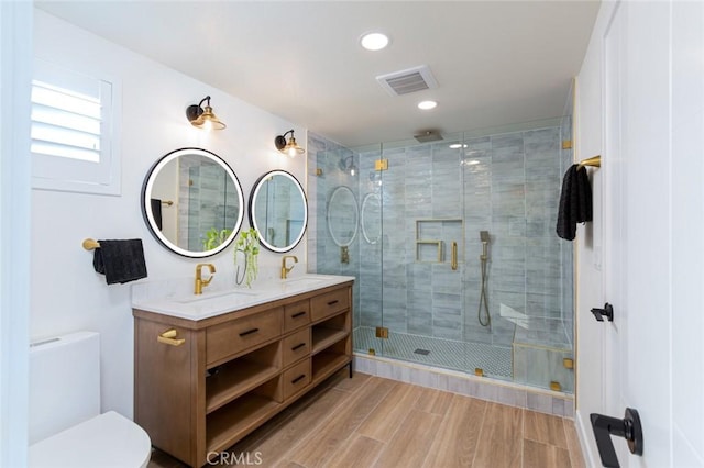 bathroom with vanity, toilet, and a shower with shower door