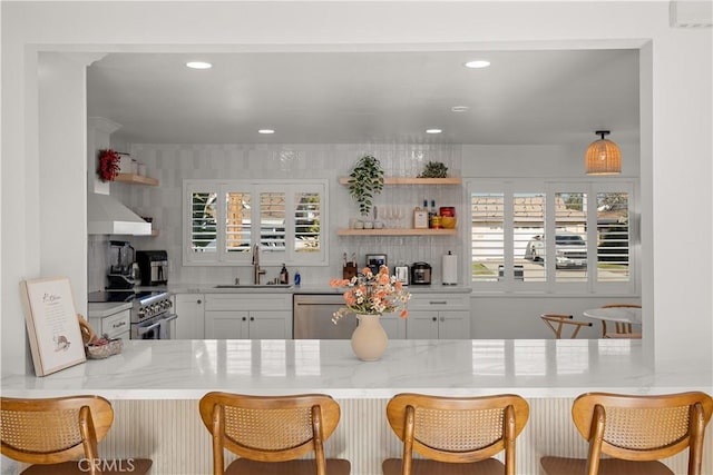 16261 Angler Ln, Huntington Beach, CA 92647 - kitchen featuring light stone countertops, a sink, open shelves, extractor fan, and appliances with stainless steel finishes