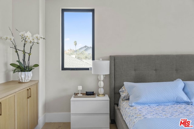 bedroom with multiple windows and hardwood / wood-style floors