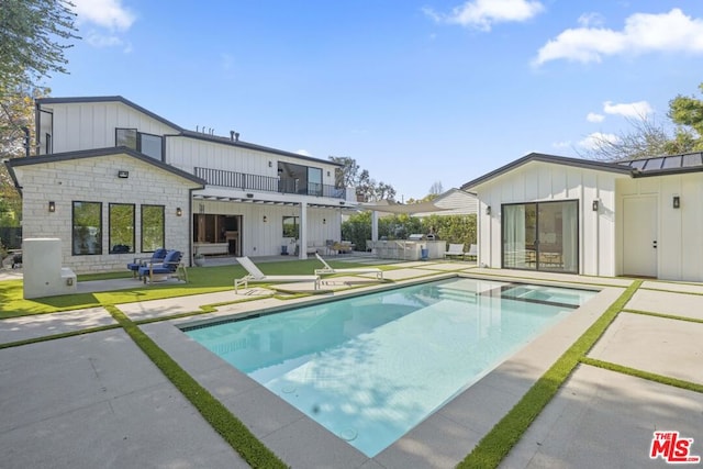 rear view of property featuring a patio area, outdoor lounge area, and a balcony