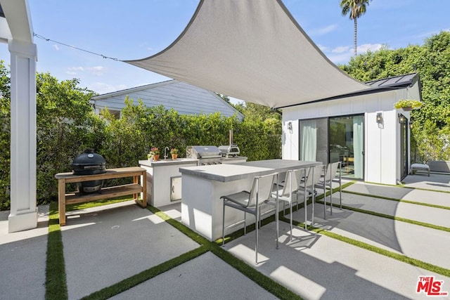 view of patio featuring a grill, area for grilling, and an outdoor bar